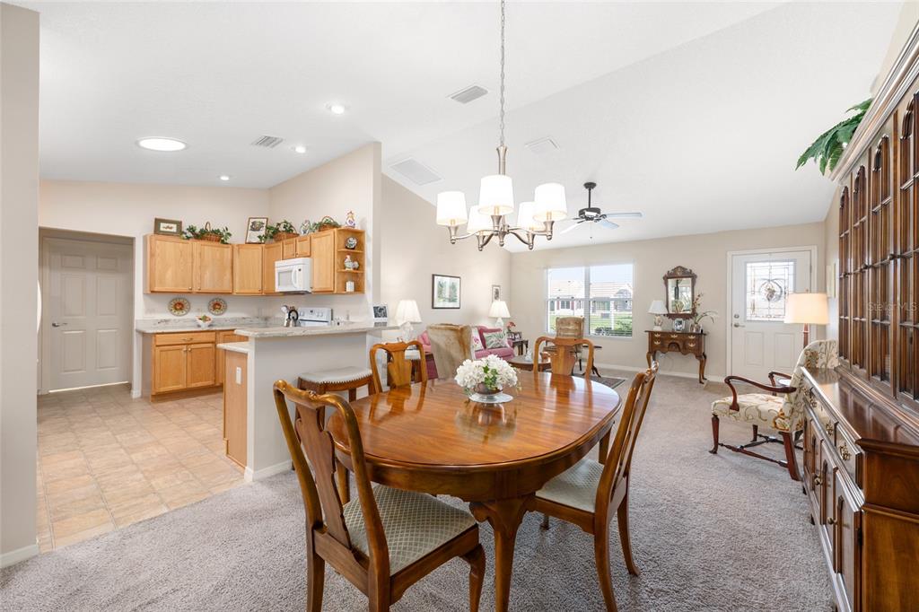 771 Fenwick Loop The Villages, FL 32163 - Photo 15 of 51 a view of a dining room and livingroom with furniture a chandelier and kitchen view