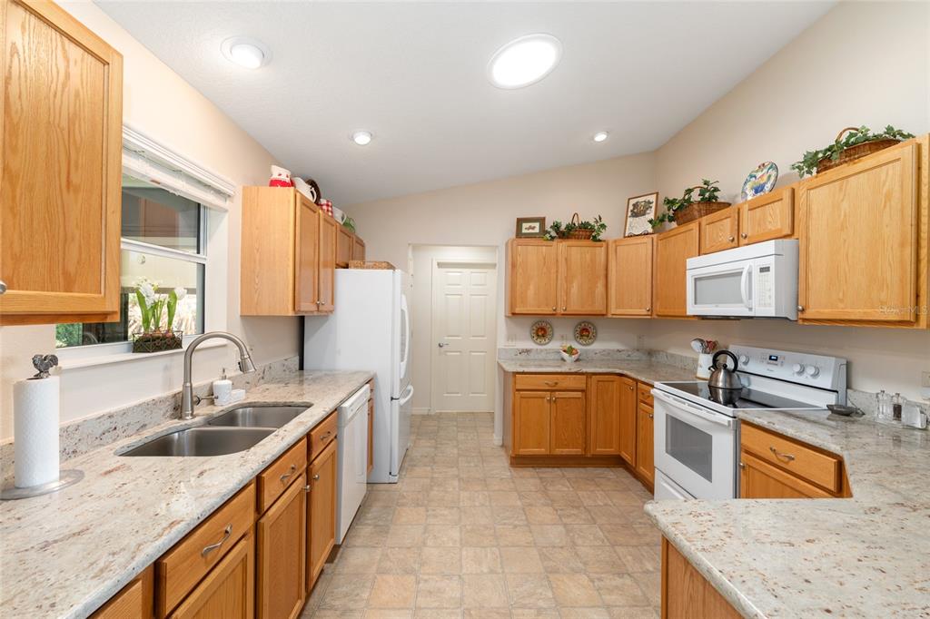 771 Fenwick Loop The Villages, FL 32163 - Photo 20 of 51 a kitchen with stainless steel appliances granite countertop a sink stove and refrigerator