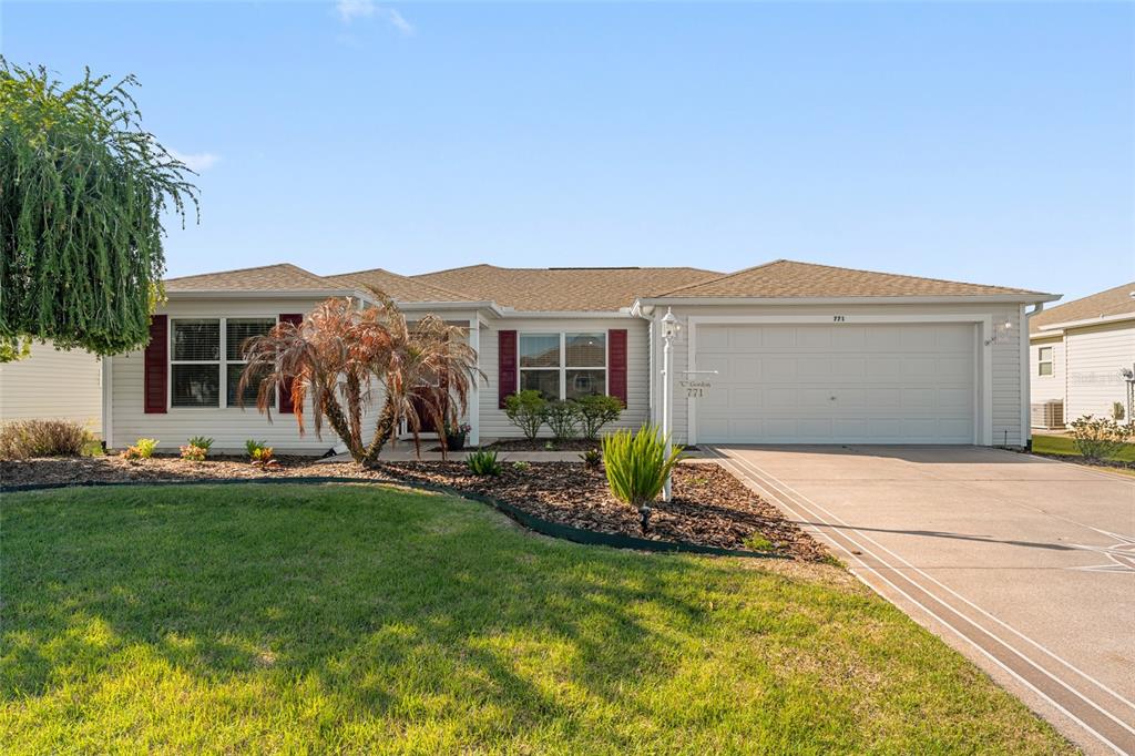 771 Fenwick Loop The Villages, FL 32163 - Photo 2 of 51 a front view of a house with a garden and yard