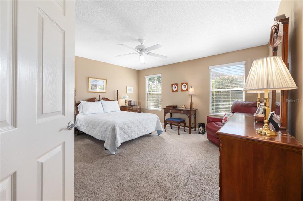 771 Fenwick Loop The Villages, FL 32163 - Photo 24 of 51 a bedroom with a bed and a chandelier