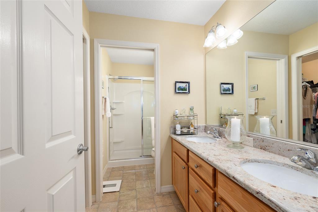771 Fenwick Loop The Villages, FL 32163 - Photo 30 of 51 a bathroom with a granite countertop sink mirror and a shower