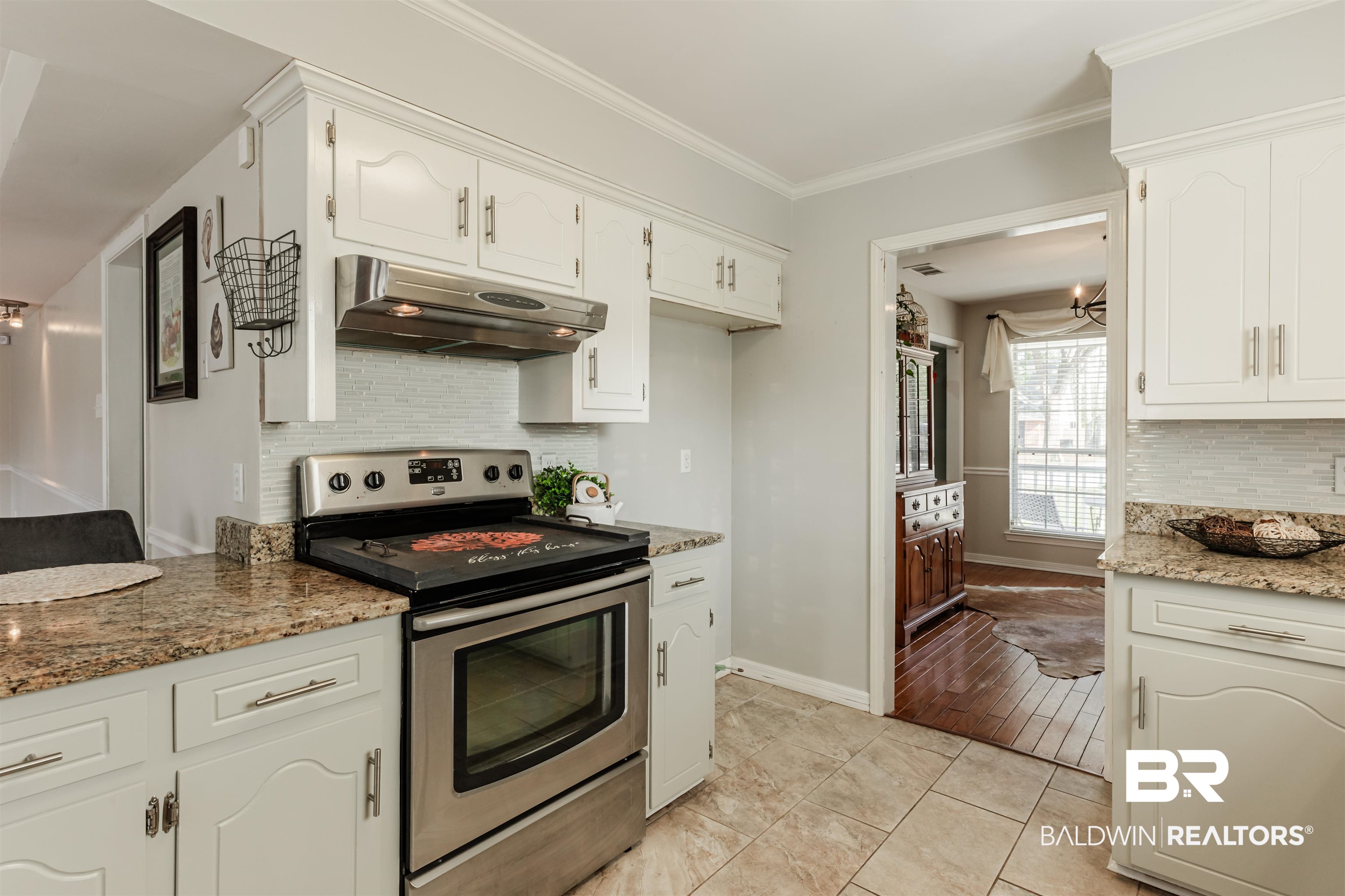 3844 Isabel Way South Mobile, AL 36693 - Photo 10 of 49 Kitchen with white cabinetry, stainless steel range with electric stovetop, ornamental molding, stone counters, and decorative backsplash