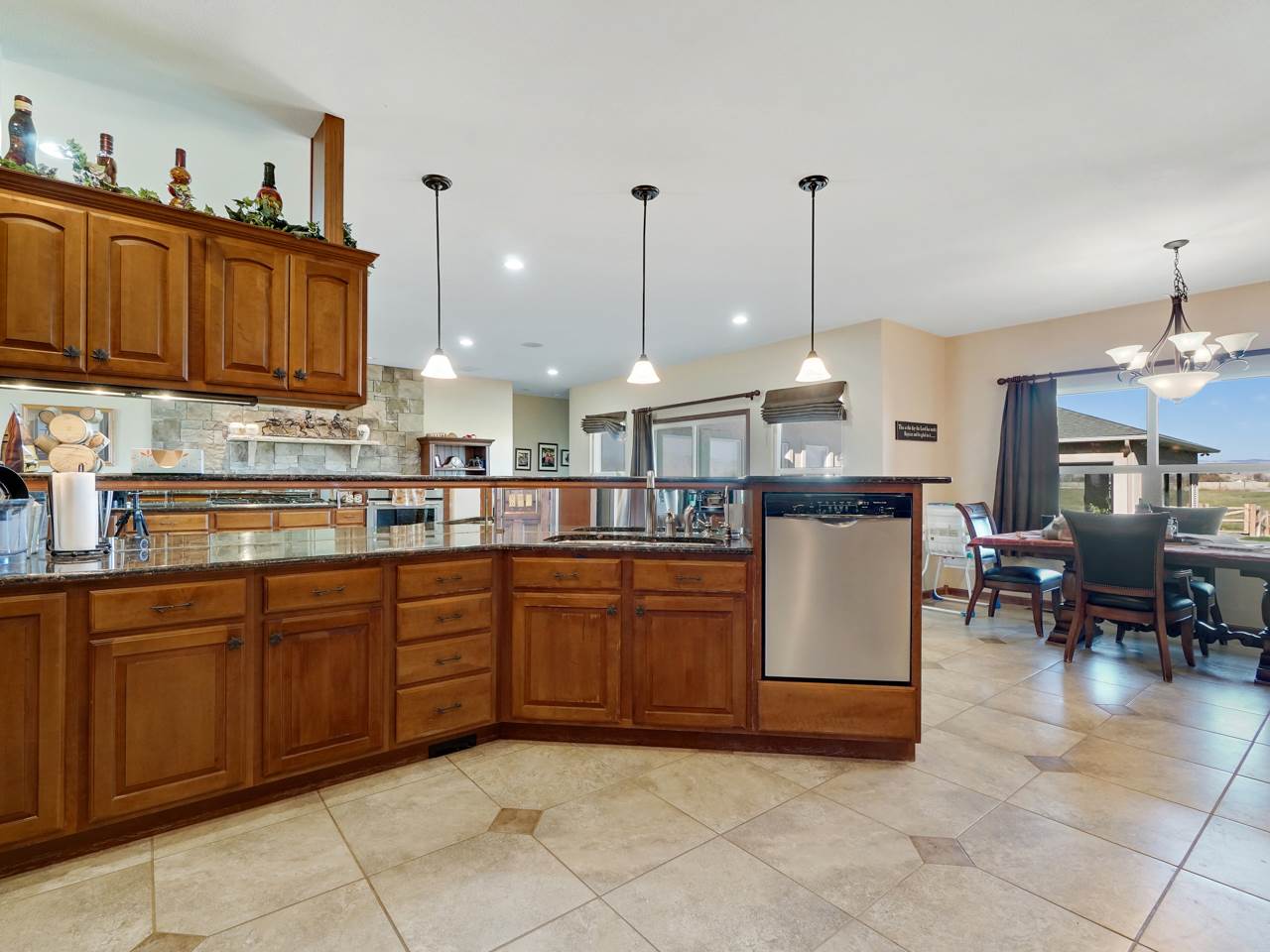 1421 19 Road Fruita, CO 81521 - Photo 25 of 36 a kitchen with stainless steel appliances granite countertop a sink counter space and a view of living room