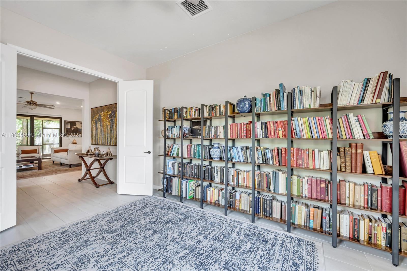 9206 Passiflora Way, Unit 101 Boca Raton, FL 33428 - Photo 37 of 60 a living room with lots of books and a book shelf