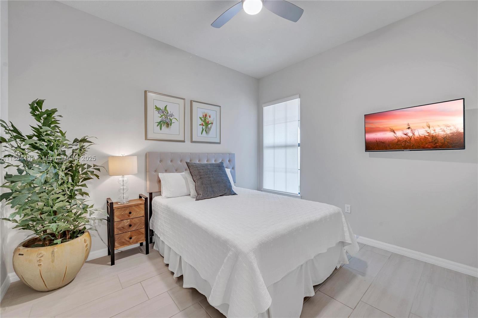9206 Passiflora Way, Unit 101 Boca Raton, FL 33428 - Photo 48 of 60 a bedroom with a bed and a potted plant
