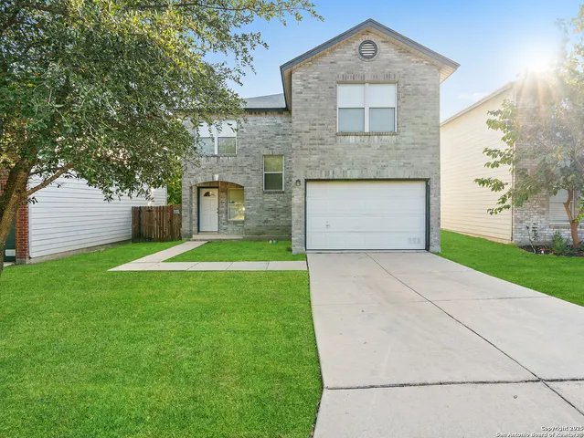 a front view of a house with a garden and garage