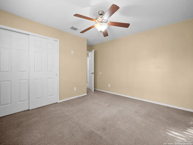 an empty room with chandelier fan