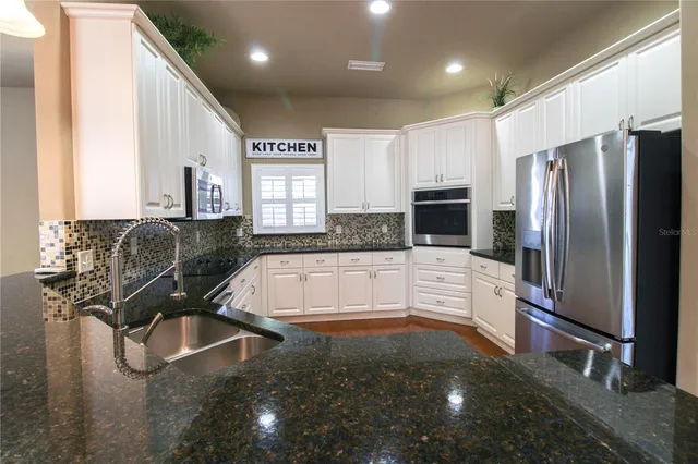 a kitchen with a sink stainless steel appliances and cabinets