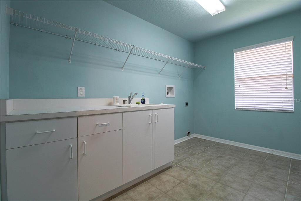 6065 Spruce Point Circle Port Orange, FL 32128 - Photo 18 of 33 a utility room with cabinets washer and dryer