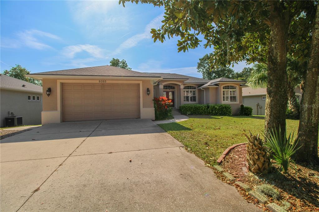 6065 Spruce Point Circle Port Orange, FL 32128 - Photo 2 of 33 a front view of a house with garden
