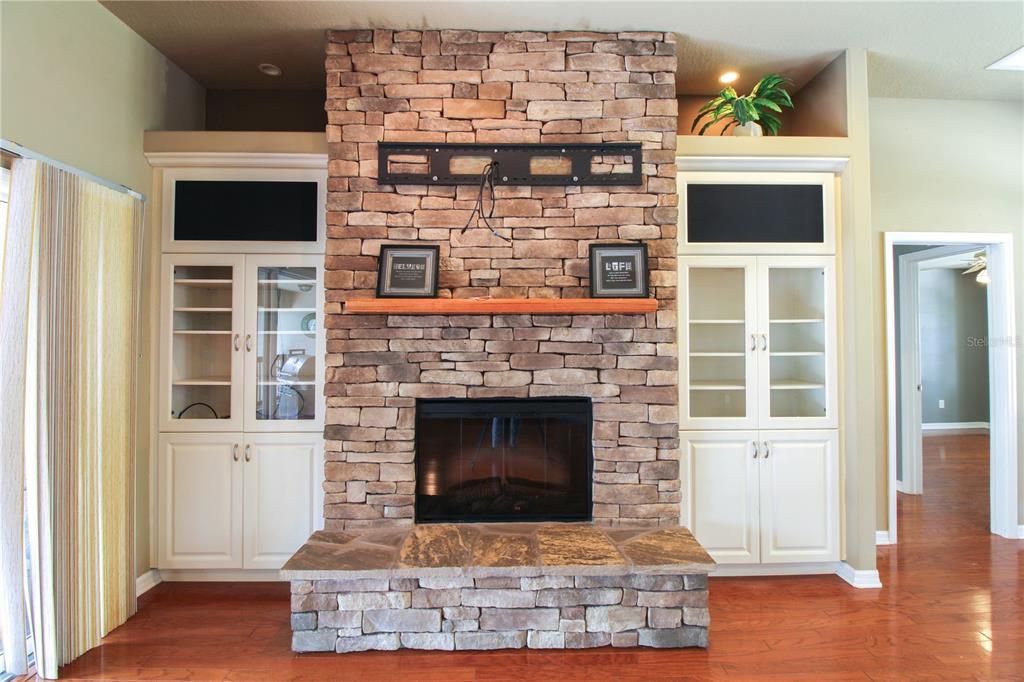 6065 Spruce Point Circle Port Orange, FL 32128 - Photo 33 of 33 a living room with a fireplace and a flat screen tv
