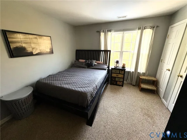 a bedroom with a bed chair and window