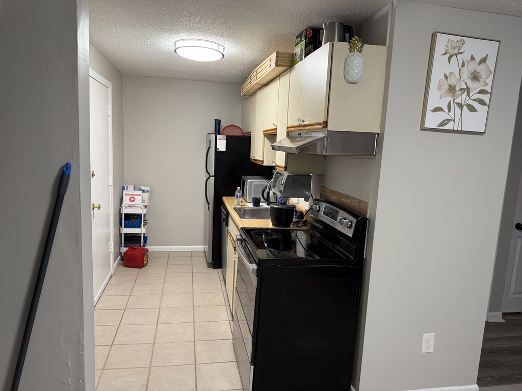 5 Turnpike Road, Unit 213 Townsend, MA 01469 - Photo 6 of 8 a kitchen with stainless steel appliances granite countertop a refrigerator and a stove