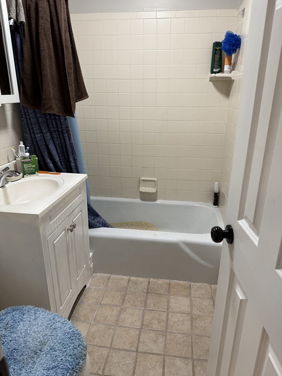 5 Turnpike Road, Unit 213 Townsend, MA 01469 - Photo 7 of 8 a bathroom with a bathtub a sink a toilet a rug and a window