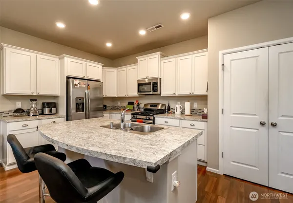 a kitchen with stainless steel appliances granite countertop a stove refrigerator sink and cabinets
