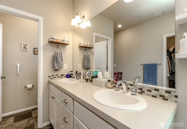 a bathroom with a double vanity sink mirror and