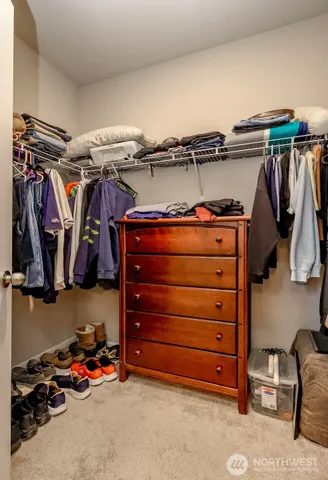 a view of walk in closet with clothes and shoes