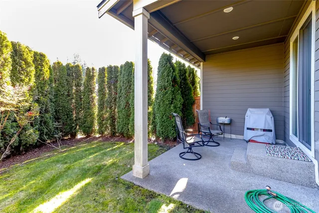 a view of a chair and table in backyard of the house