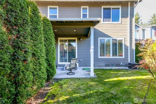 a view of a chair and table in backyard of the house
