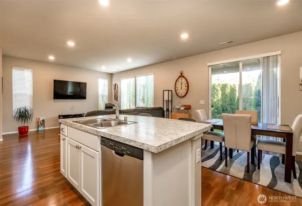 a kitchen with a table chairs a sink dishwasher and wooden floor