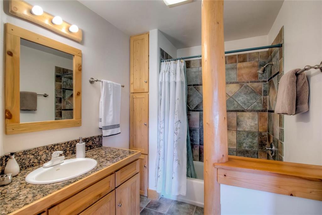 482 Idlewild Drive Dillon, CO 80435 - Photo 14 of 35 a bathroom with a granite countertop sink and a mirror