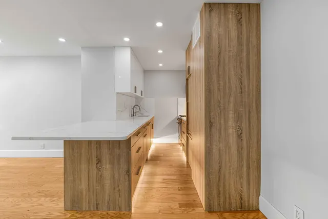 a view of a hallway with wooden floor and staircase