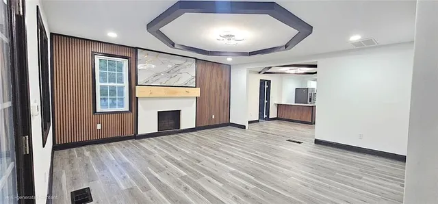 a view of empty room with wooden floor and fireplace