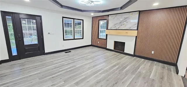 a view of an empty room with a fireplace and a window