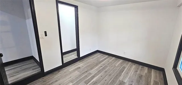 a view of a hallway with wooden floor and gate