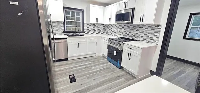 a kitchen with stainless steel appliances granite countertop a stove and a microwave