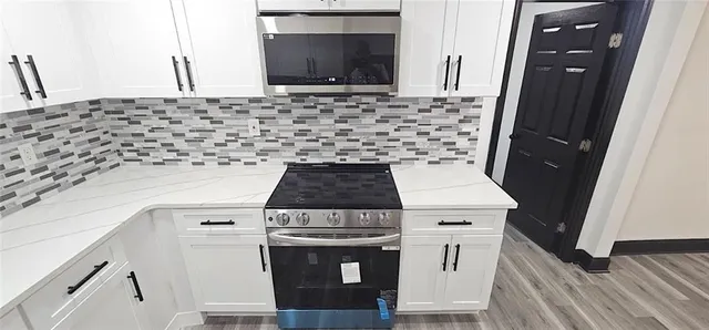 a stove top oven sitting inside of a kitchen