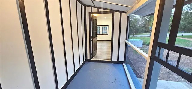 a view of a hallway with wooden floor and stairs
