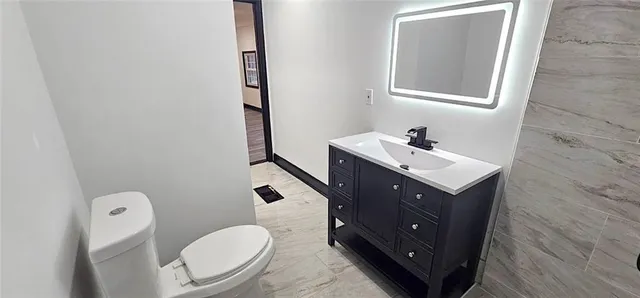 a bathroom with a toilet sink and mirror