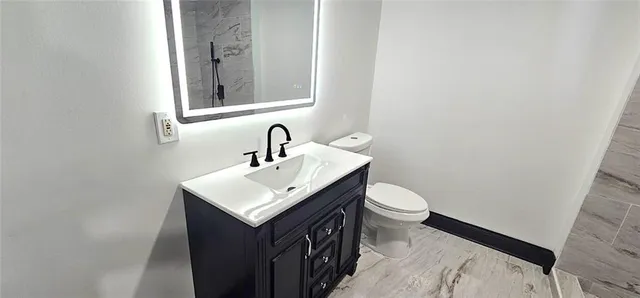 a bathroom with a sink a toilet and mirror