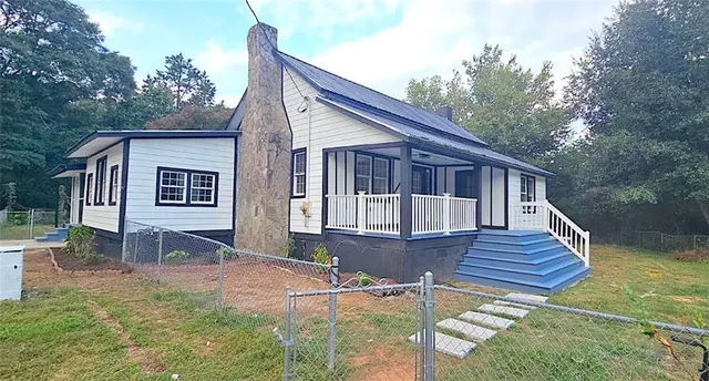 a view of a house with wooden deck front of house