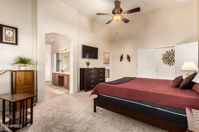 a bedroom with a bed dresser and a flat tv screen