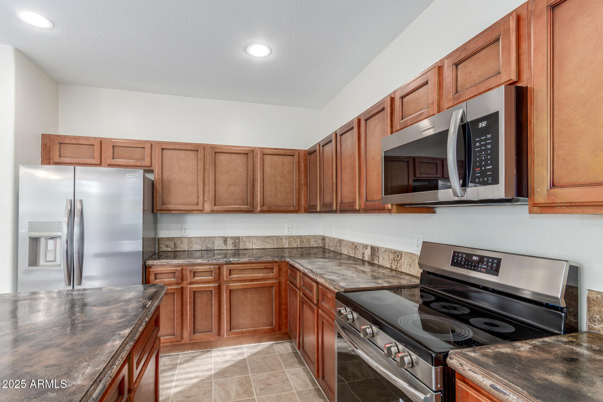 8849 West Cordes Road Tolleson, AZ 85353 - Photo 15 of 33 a kitchen with stainless steel appliances granite countertop a stove a sink and a microwave