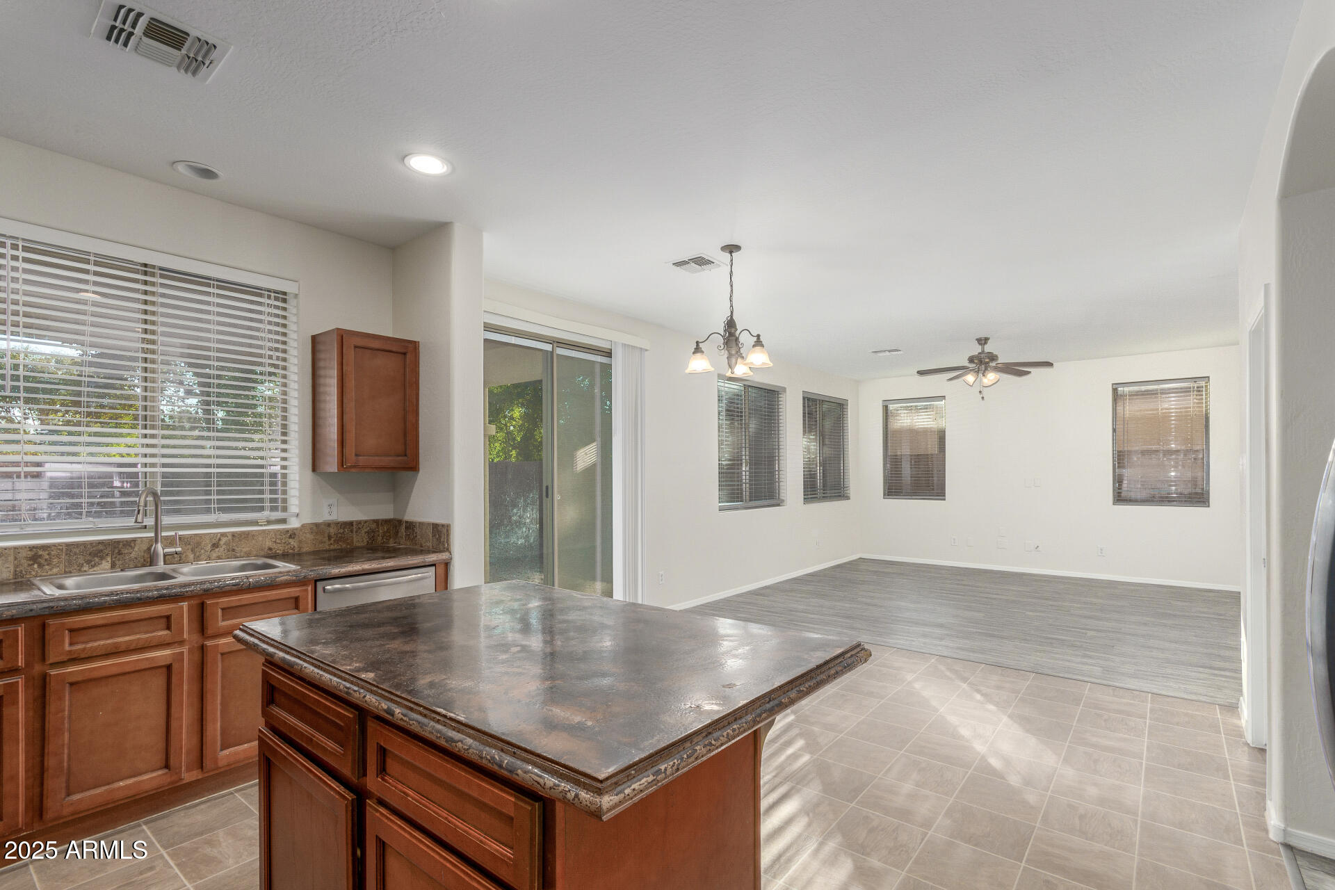 8849 West Cordes Road Tolleson, AZ 85353 - Photo 16 of 33 a kitchen with granite countertop a sink a counter top space cabinets and stainless steel appliances