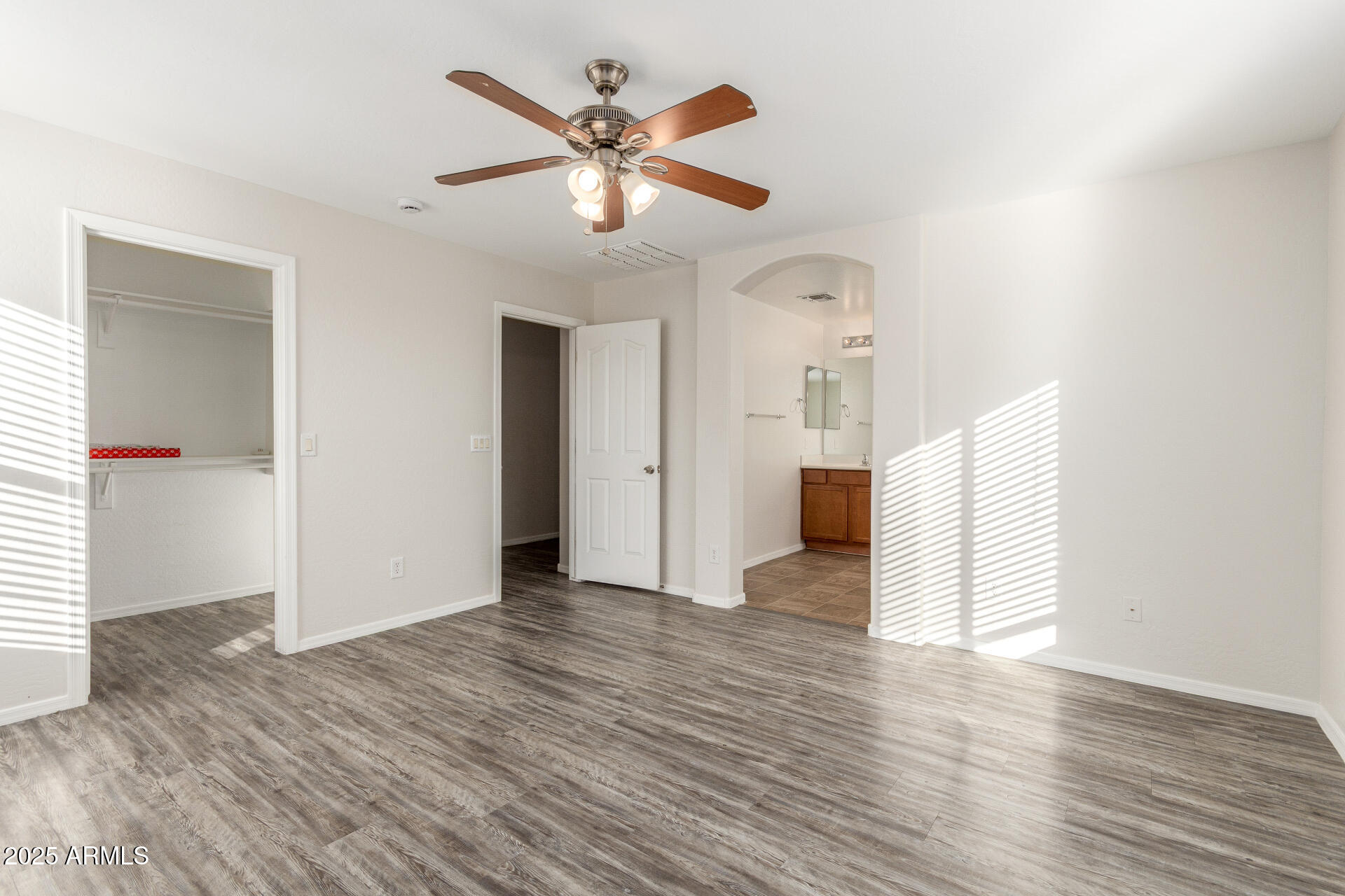 8849 West Cordes Road Tolleson, AZ 85353 - Photo 20 of 33 an empty room with wooden floor and ceiling fan