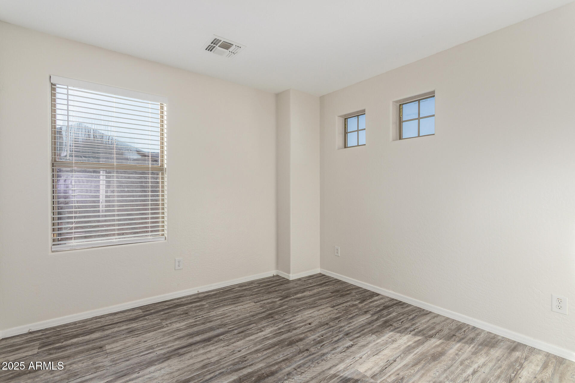 8849 West Cordes Road Tolleson, AZ 85353 - Photo 24 of 33 a view of an empty room with wooden floor and a window