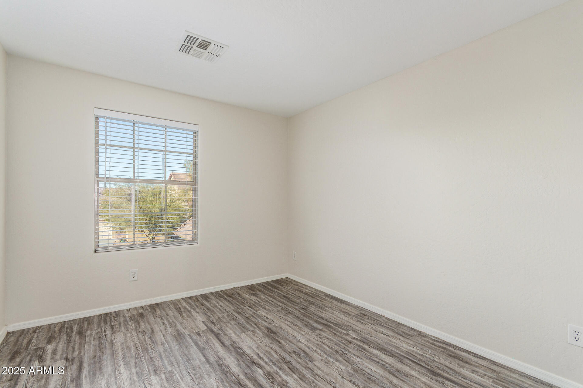 8849 West Cordes Road Tolleson, AZ 85353 - Photo 26 of 33 an empty room with wooden floor and windows