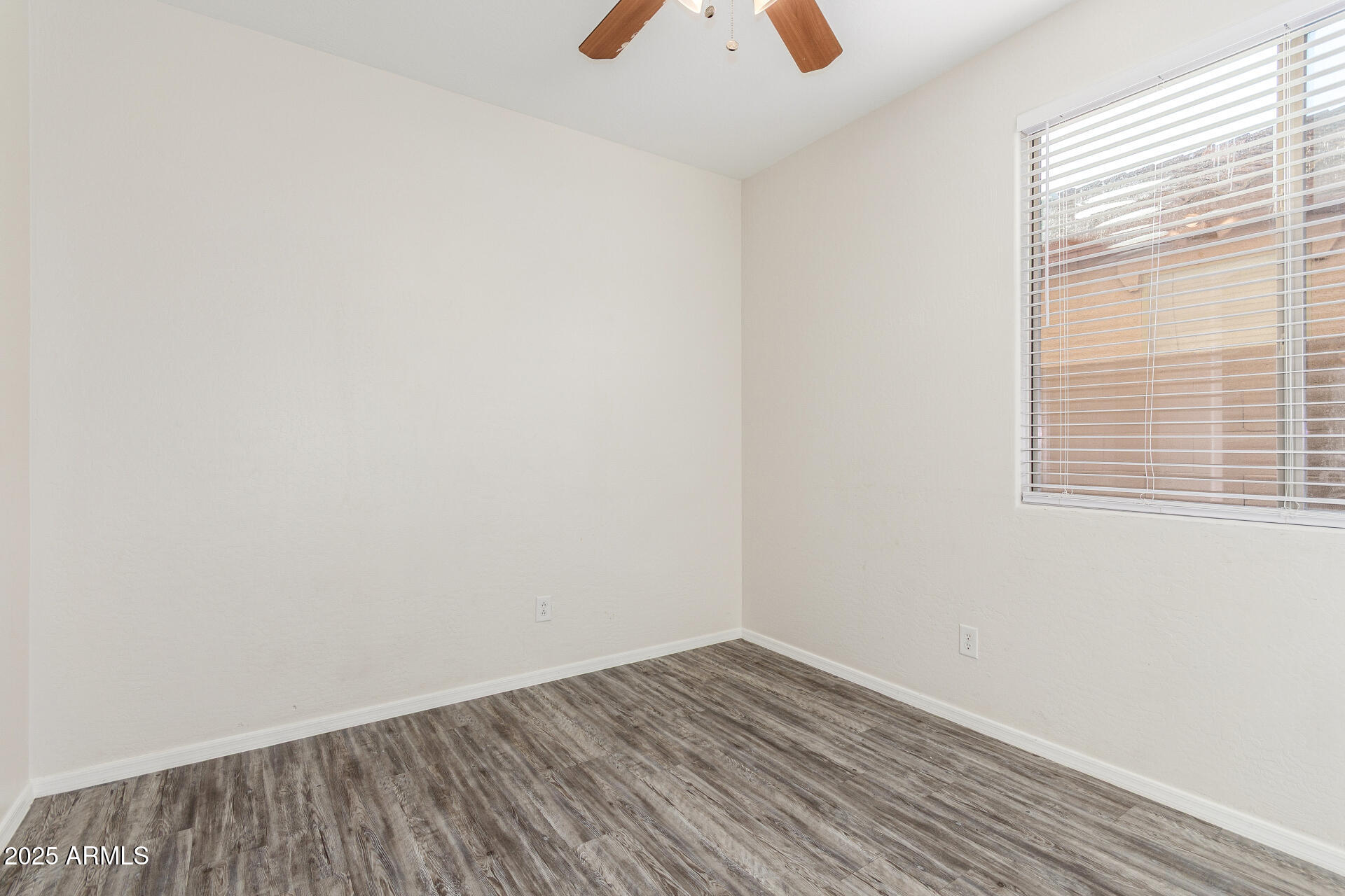 8849 West Cordes Road Tolleson, AZ 85353 - Photo 27 of 33 a view of an empty room with wooden floor and a window