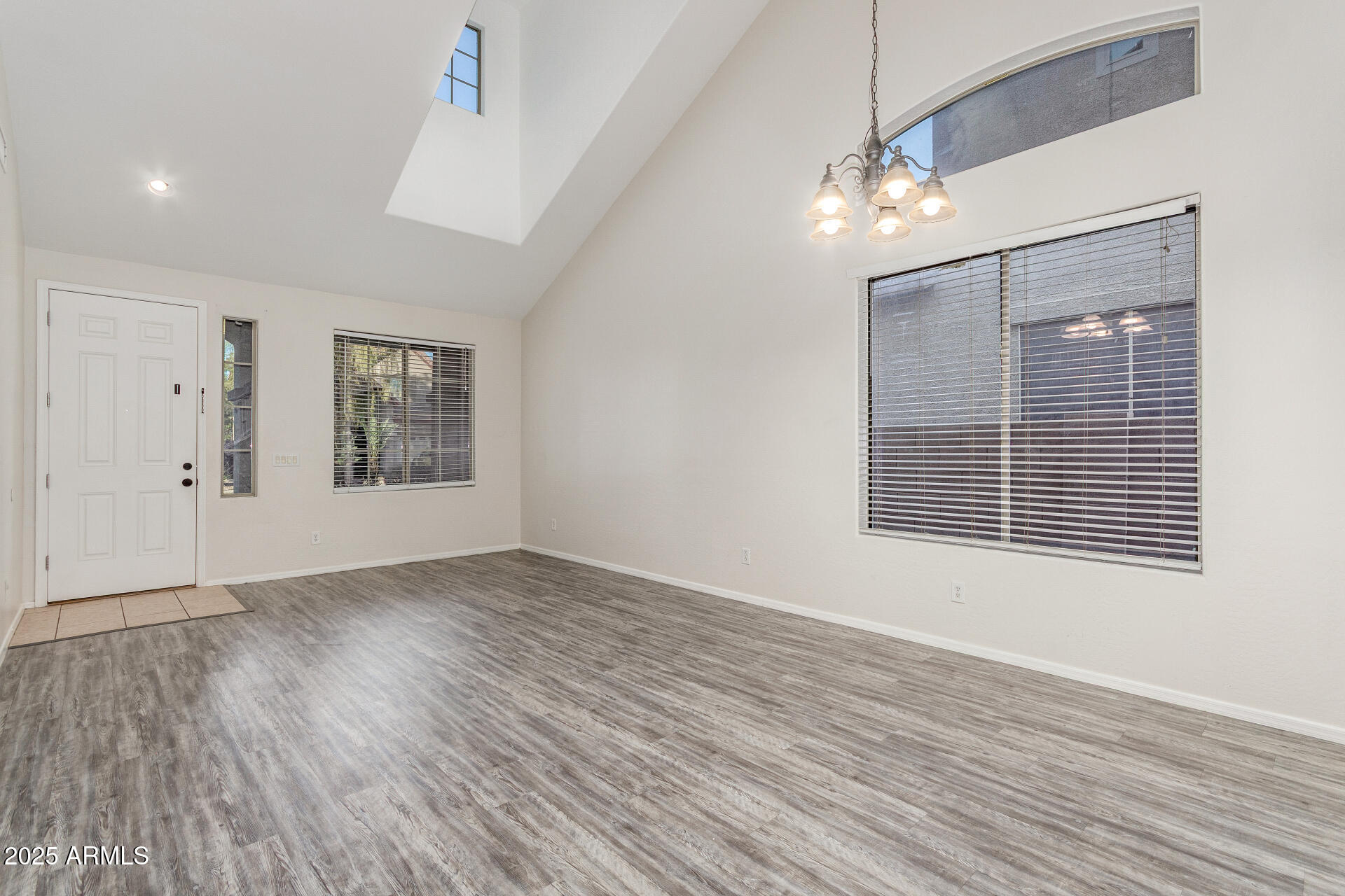 8849 West Cordes Road Tolleson, AZ 85353 - Photo 6 of 33 a view of an empty room with wooden floor and a window
