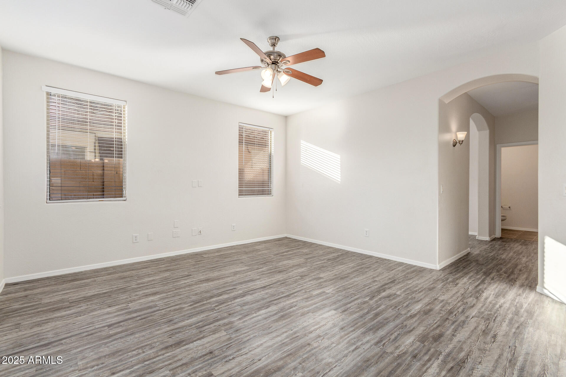 8849 West Cordes Road Tolleson, AZ 85353 - Photo 8 of 33 a view of an empty room with wooden floor and a window