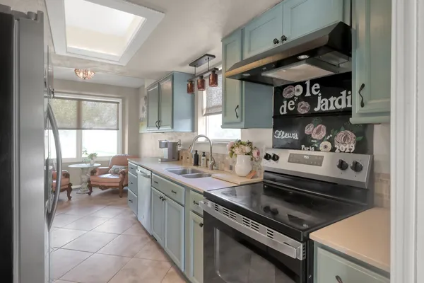 a kitchen with stainless steel appliances a sink a stove and a window