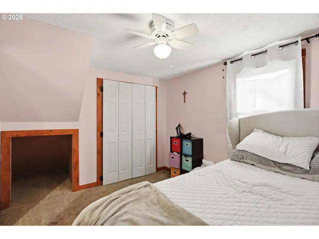 a bedroom with a bed and a ceiling fan