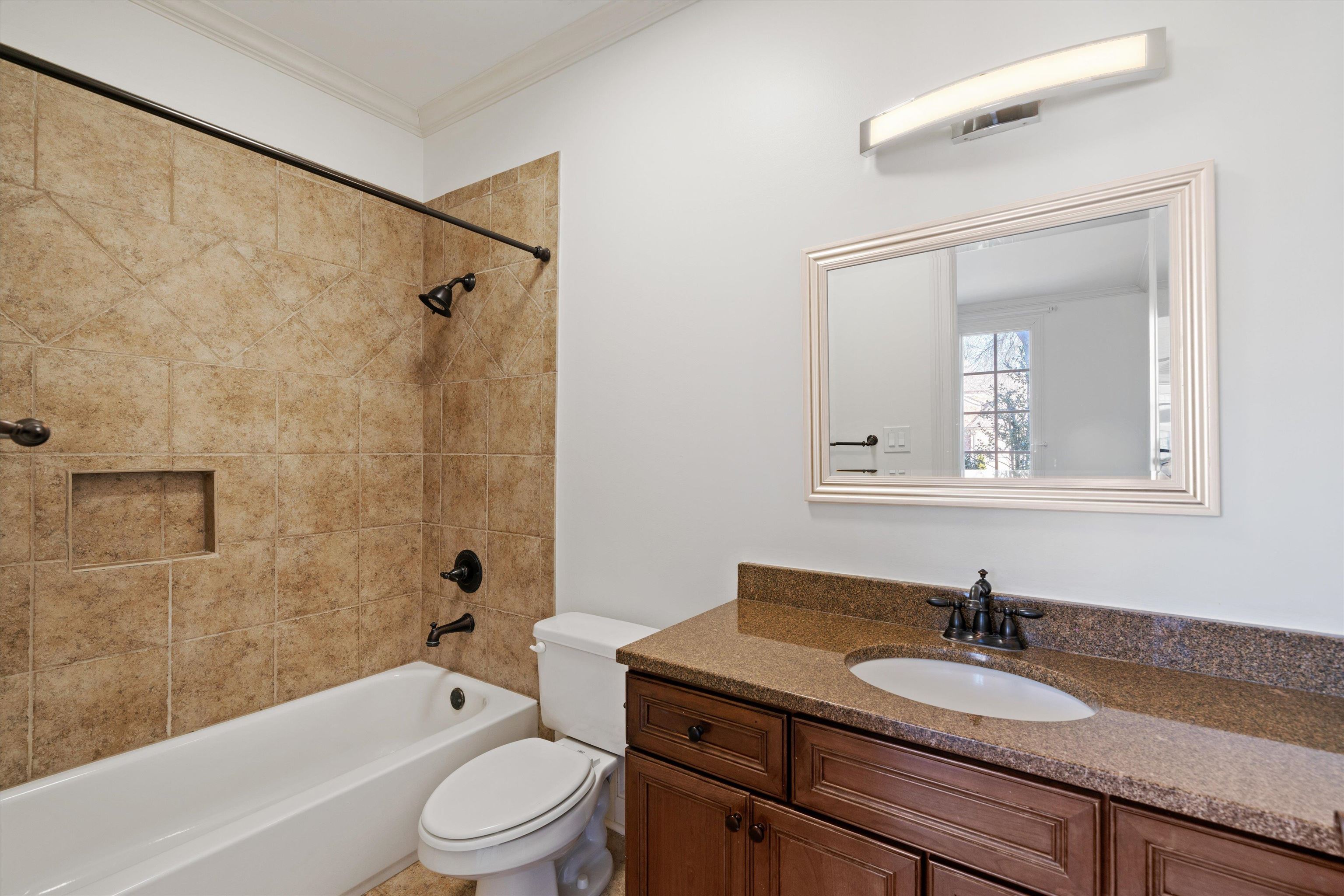 1247 Braywind Drive Collierville, TN 38017 - Photo 22 of 35 a bathroom with a granite countertop sink a toilet a mirror and shower