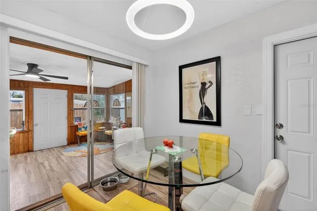 a living room with stainless steel appliances furniture a rug and a kitchen