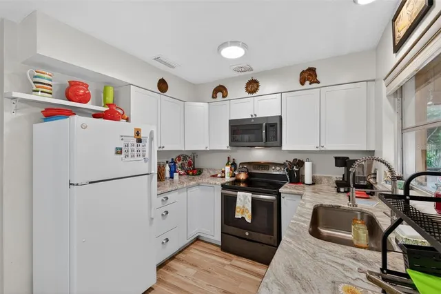 a kitchen with stainless steel appliances a stove a sink and a microwave