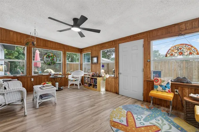 a dining room with wooden floor a chandelier a glass table and chairs